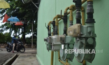  Warga berjalan didekat meteran jaringan gas rumah tangga PGN.