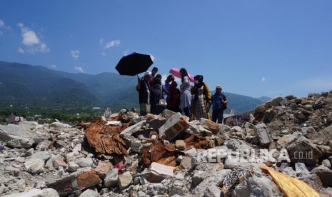 Warga berjalan disekitar lokasi bekas pemukiman mereka yang hancur akibat bencana gempa dan likuefaksi di Perumnas Balaroa, Palu, Sulawesi Tengah, Ahad (11/8/2019). Lagu 