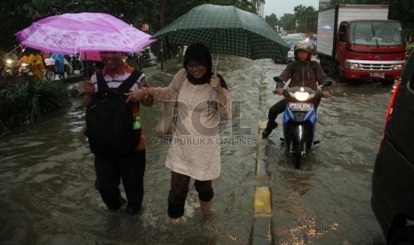  Warga berjalan kaki menerobos banjir yang menggenangi jalan Rasuna Said, Jakarta Selatan, Rabu (6/2).  (Republika/Yasin Habibi)