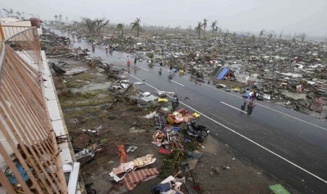  Warga berjalan melewati pemukiman yang hancur akibat Topan Haiyan di kota Tacloban, Leyte provinsi Leyte, Filipina tengah, Ahad (10/11).  (AP/Bullit Marquez)