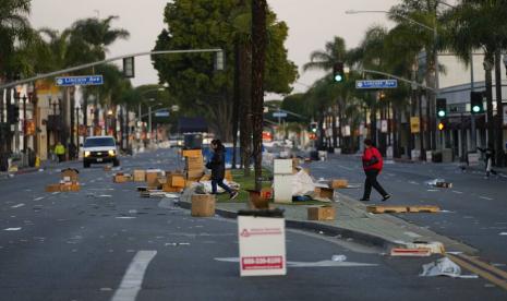 Warga berjalan melintasi lokasi festival Tahun Baru Imlek setelah dibatalkan karena penembakan massal di Monterey Park, California, Ahad, 22 Januari 2023. Seorang pria bersenjata membunuh beberapa orang di sebuah studio dansa pada Sabtu (21/1/2023) malam di tengah perayaan Tahun Baru Imlek di komunitas Monterey Park yang didominasi orang Asia-Amerika.