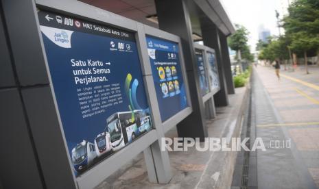 Warga berjalan melintasi papan informasi mengenai JakLingko di Jakarta. Ketua Bidang Advokasi dan Kemasyarakatan Masyarakat Transportasi Indonesia (MTI) Pusat Djoko Setijowarno menilai penerapan protokol kesehatan (prokes) pada moda transportasi ibu kota di bawah jaringan Jaklingko sudah ketat.