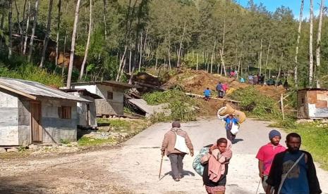 Warga berjalan membawa barang-barangnya di wilayah lokasi longsor yang melanda Desa Kaokalam, Provinsi Enga, Papua Nugini, Jumat, 24 Mei 2024.