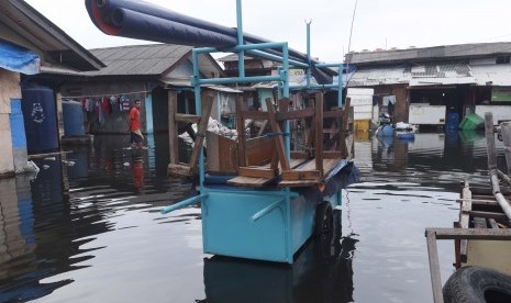 Warga berjalan menembus banjir di Kawasan Muara Angke, Jakarta, Selasa (10/1).