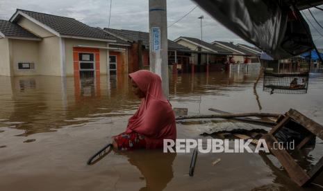 Warga berjalan menembus banjir yang merendam Perumahan Pesona Harapan Indah akibat luapan Sungai Sail di Pekanbaru, Riau, Kamis (22/4/2021). Hujan deras yang mengguyur Kota Pekanbaru mengakibatkan Sungai Sail meluap dan merendam permukiman warga hingga ketinggian air mencapai 1,5 meter di beberapa lokasi sehingga puluhan Kepala Keluarga terpaksa mengungsi sementara ke tempat yang lebih aman. 