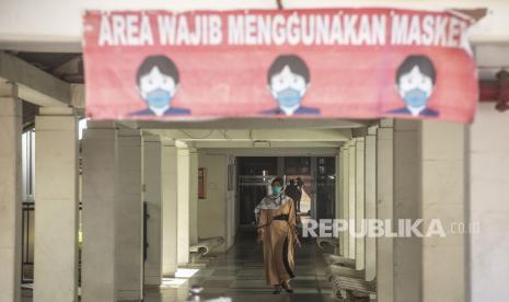 Warga berjalan menggunakan masker di RSPI Sulianti Saroso, Jakarta, Selasa (10/3/2020).