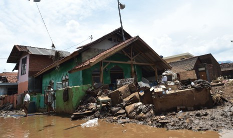 Warga berjalan seusai melaksanakan Salat Jumat di Masjid Al Mukmin yang berada di lokasi bencana banjir bandang aliran Sungai Cimanuk, Kampung Cimacan, Tarogong, Kabupaten Garut, Jawa Barat, Jumat (23/9). 