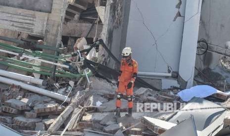 Warga berkomunikasi dengan sanak saudaranya yang menjadi korban gempa dan tsunami di Hotel Roa Roa, Palu, Sulawesi Tengah, Ahad (30/9).