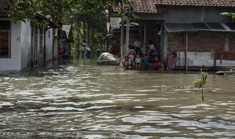 Warga berkumpul di sebuah rumah menunggu genangan banjir surut di Cilacap, Jateng. BMKG mengimbau masyarakat Jateng mewaspadai bencana hidrometeorologi.