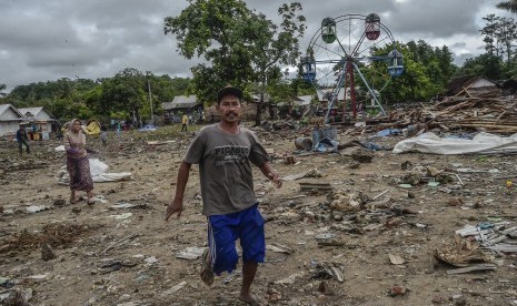 Warga berlari saat air laut pasang di Desa Sumur, Banten, Selasa (25/12/2018).