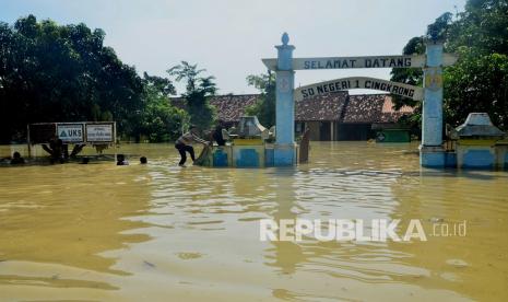 Warga bermain di depan sekolah yang tergenang air di Desa Cingrong, Purwodadi, Grobogan, Jawa Tengah, Rabu (16/3/2022). (Ilustrasi)