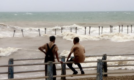  Warga bermain di pingiran pantai Tedis saat cuaca ekstrim melanda Kota Kupang, NTT