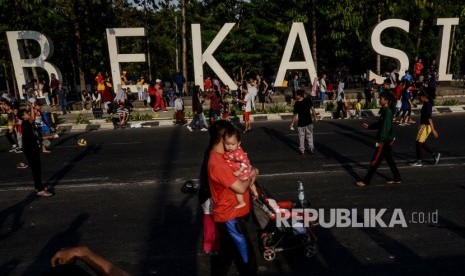 Warga berolahraga di area hari bebas kendaraan bermotor (HBKB) di Kota Bekasi, Jawa Barat. 