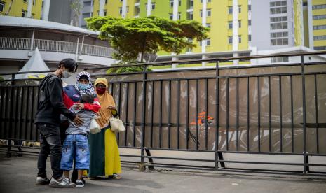 Warga berpelukan dengan keluarganya usai menjalani isolasi di Rusun Pasar Rumput, Jakarta, Ahad (30/1/2022).