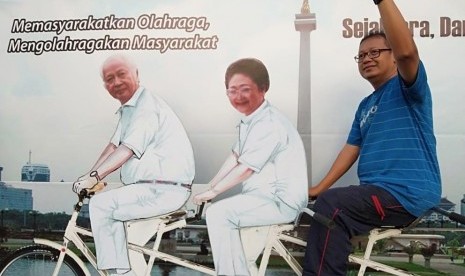 Warga berpose dengan foto Pak Harto yang naik sepeda.