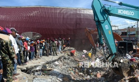  Warga bersama aparat melakukan evakuasi lanjutan di reruntuhan ruko di Pasar Meureudu, Pidie Jaya, NAD, Kamis (8/12).