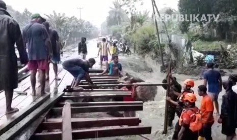 Warga bersama Baznas membangun jembatan darurat yang rusak akibat banjir bandang di Kelurahan Hinekombe, Sentani, Papua.