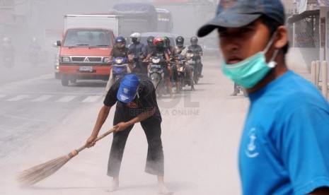  Warga bersama petugas TNI dan Kepolisian membersihkan abu vulkanik yang menyelimuti Jalan MT Haryono, Kutoarjo, Purworejo, Jawa Tengah, Sabtu (15/2). (Republika/Adhi Wicaksono)