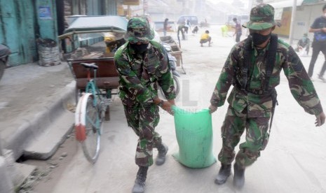  Warga bersama petugas TNI dan Kepolisian membersihkan abu vulkanik yang menyelimuti Jalan MT Haryono, Kutoarjo, Purworejo, Jawa Tengah, Sabtu (15/2). (Republika/Adhi Wicaksono)