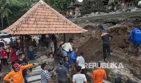 Warga bersama tim Badan Penanggulangan Bencana Daerah (BPBD) mencari korban tewas akibat longsor pada senderan penahan tebing Pura Bukit Desa Bitera, Gianyar, Senin (5/2). 