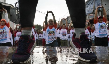  Warga bersama tim senam Sohib Anies Sandy melakukan senam bersama di Suka Mulia Jakarta Pusat, Ahad (2/4).