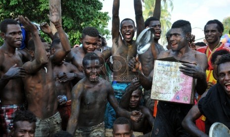 Warga bersorak saat memenangkan panjat pinang pada peringatan HUT Kemerdekaan ke-70 Republik Indonesia di Kota Sorong, Papua, Senin (17/8).   (Republika/Rakhmawaty La’lang)a