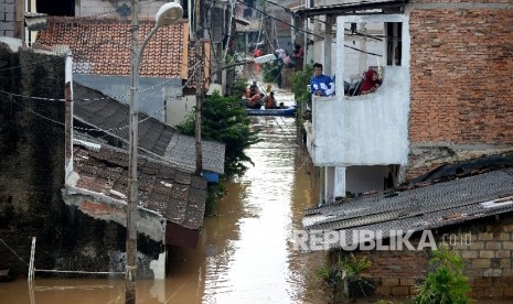 Warga bertahan dirumahnya ketika banjir di Kelurahan Cipinang Melayu, Kecamatan Makassar, Jakarta, Selasa (21/2).