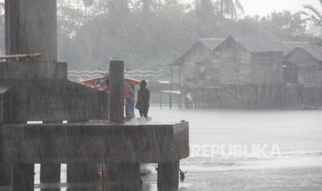 Warga berteduh di bawah jembatan saat hujan turun. Ilustrasi