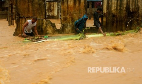 Warga berupaya memindahkan material yang terbawa banjir akibat meluapnya sungai di Maluku (ilustrasi)