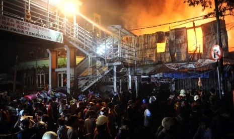  Warga berusaha memadamkan api saat kebakaran melanda kawasan pasar Gembrong dan pemukiman di Prumpung, Jakarta, Selasa (4/8)malam. 