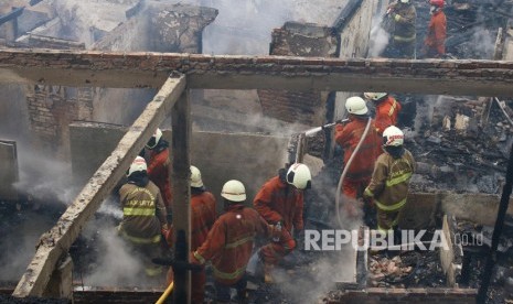 Warga berusaha memadamkan api saat terjadi kebakaran di Johar Baru, Jakarta, Senin (5/8/2019).