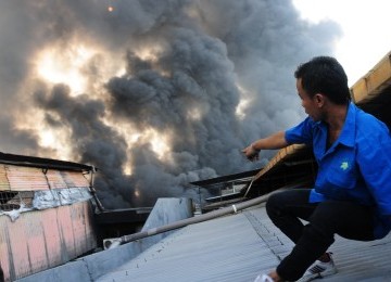 Warga berusaha memadamkan api yang membakar sebuah gudang pabrik plastik di Gang Semut RT 5 RW 3 Kapuk, Cengkareng, Jakarta Barat, Senin (13/22). (Republika/Aditya Pradana Putra)