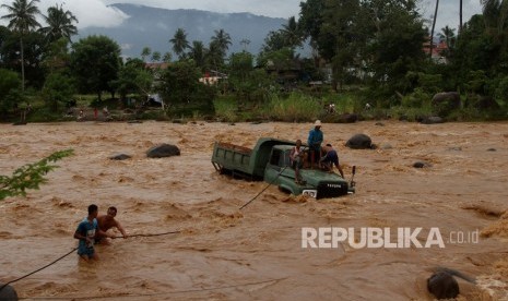 Pemkot Padang Diminta Petakan Daerah Rawan Banjir. Warga berusaha menarik mobil truk pengangkut batu yang berada di tengah sungai Batang Kuranji akibat terseret banjir di Kecamatan Pauh, Padang, Sumatra Barat.