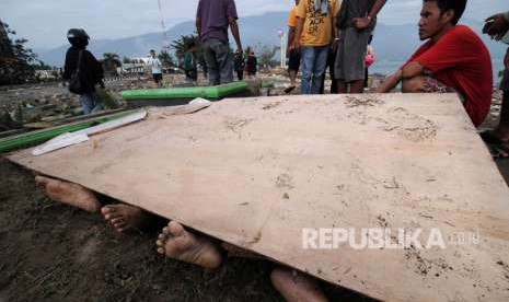 Warga berusaha mengidentifikasi anggota keluarganya di antara jenazah korban gempa dan tsunami di Pantai Talise Palu, Sulawesi Tengah, Sabtu (29/9).