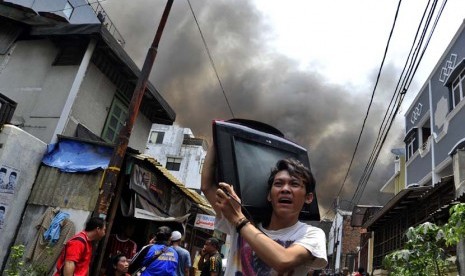  Warga berusaha menyelamatkan barang miliknya saat kebakaran terjadi di Jalan Labu, Mangga Besar, Jakarta, Jumat (28/9).  (Fanny Octavianus/Antara)