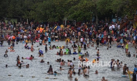   Warga berwisata di Pantai Ancol, Jakarta, Senin (26/6).