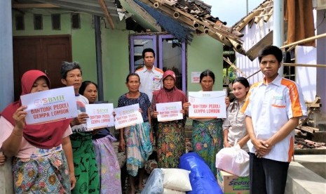 Warga besama relawan BMH foto bersama untuk simbolis penyerahan bantuan di Lombok Timur.