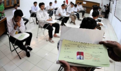 Warga binaan menjalani Ujian Nasional di Lembaga Pemasyarakatan Cipinang, Jakarta Timur, Senin (13/4). 