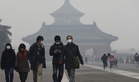 Warga China mengenakan masker untuk menghindari polusi udara di Beijing. Lockdown selama pandemi membersihkan udara bumi tapi kini efek itu mulai hilang. Ilustrasi.