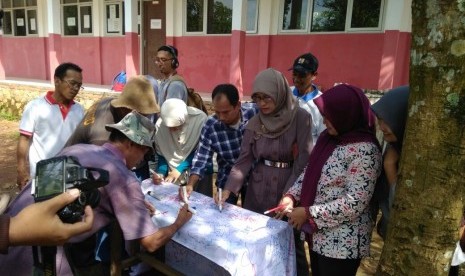 Warga dan guru sekolah SDN Leuwibatu, Bogor bertandatangan di atas selembar kain putih sebagai simbol mendukung KPK