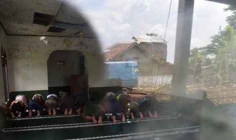 Warga dan relawan melaksanakan Salat Jumat di Masjid Al Mukmin yang berada di lokasi bencana banjir bandang aliran Sungai Cimanuk, Kampung Cimacan, Tarogong, Kabupaten Garut, Jawa Barat, Jumat (23/9).