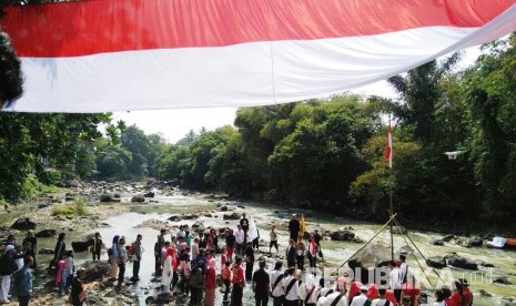 Warga dan sejumlah komunitas di Kota Sukabumi menggelar upacara hari kemerdekaan dan membentangkan bendera merah putih sepanjang 72 meter di pinggir Sungai Cimandiri, Kecamatan Lembursitu, Rabu (17/8).