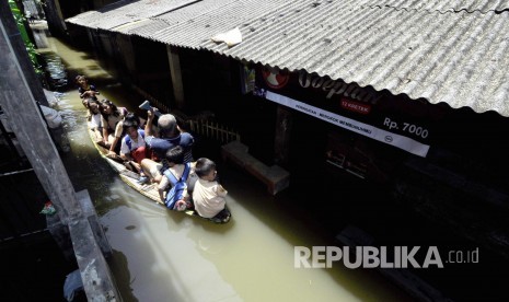 Warga dan siswa SD melintasi genangan air menggunakan perahu di Desa Cigosol, Kecamatan Baleendah, Kabupaten Bandung, Jumat (3/3). 