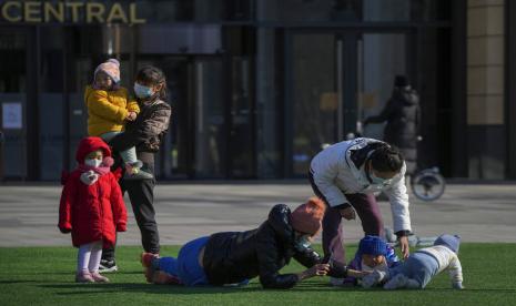  Warga dengan anak-anak dan balita mereka bermain di lapangan hijau di luar mal di Beijing, Ahad, 4 Desember 2022 (ilustrasi). Pakar mengatakan Cina harus memperkuat inisiatif untuk masyarakat membangun keluarga. Saat jatuhnya angka kelahiran di dapat mengancam perekonomian terbesar kedua di dunia.