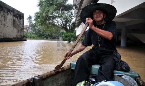   Warga dengan menggunakan perahu mencoba melintasi banjir luapan air sungai Ciliwung di Jalan H Bawah, Kelurahan Kebon Baru, Kecamatan Tebet, Jakarta Selatan, Rabu (22/1).   (Republika/Prayogi)