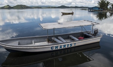 Warga dengan perahu kecil melintas di kawasan Khalkote, Jayapura, Papua, Senin (13/11). Kawasan Khalkote di danau Sentani akan menjadi pusat kemeriahan pelaksanaan olahraga air pada PON 2020 di Papua.