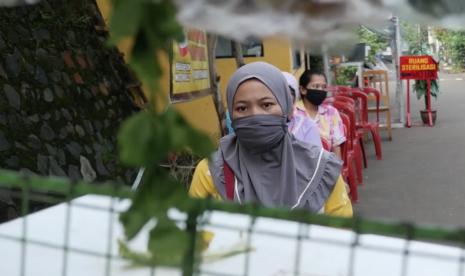 Warga Depok terapkan physical distancing saat berbelanja sayuran.