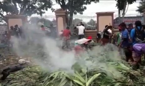 warga desa Banti dan Kimbeli melaksanakan tradisi adat bakar batu di halaman Graha Eme Neme Yauware.