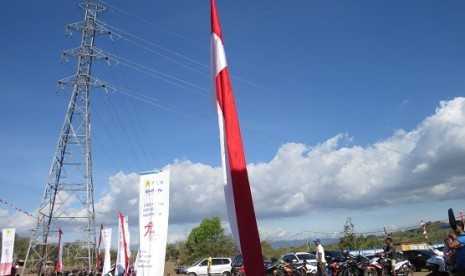 Warga desa beraktivitas di dekat jaringan listrik milik PLN Wilayah NTT.