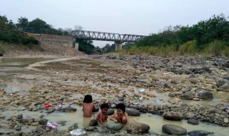 Warga Desa Cibarusah Kota sedang mandi di Kali Cipamingkis